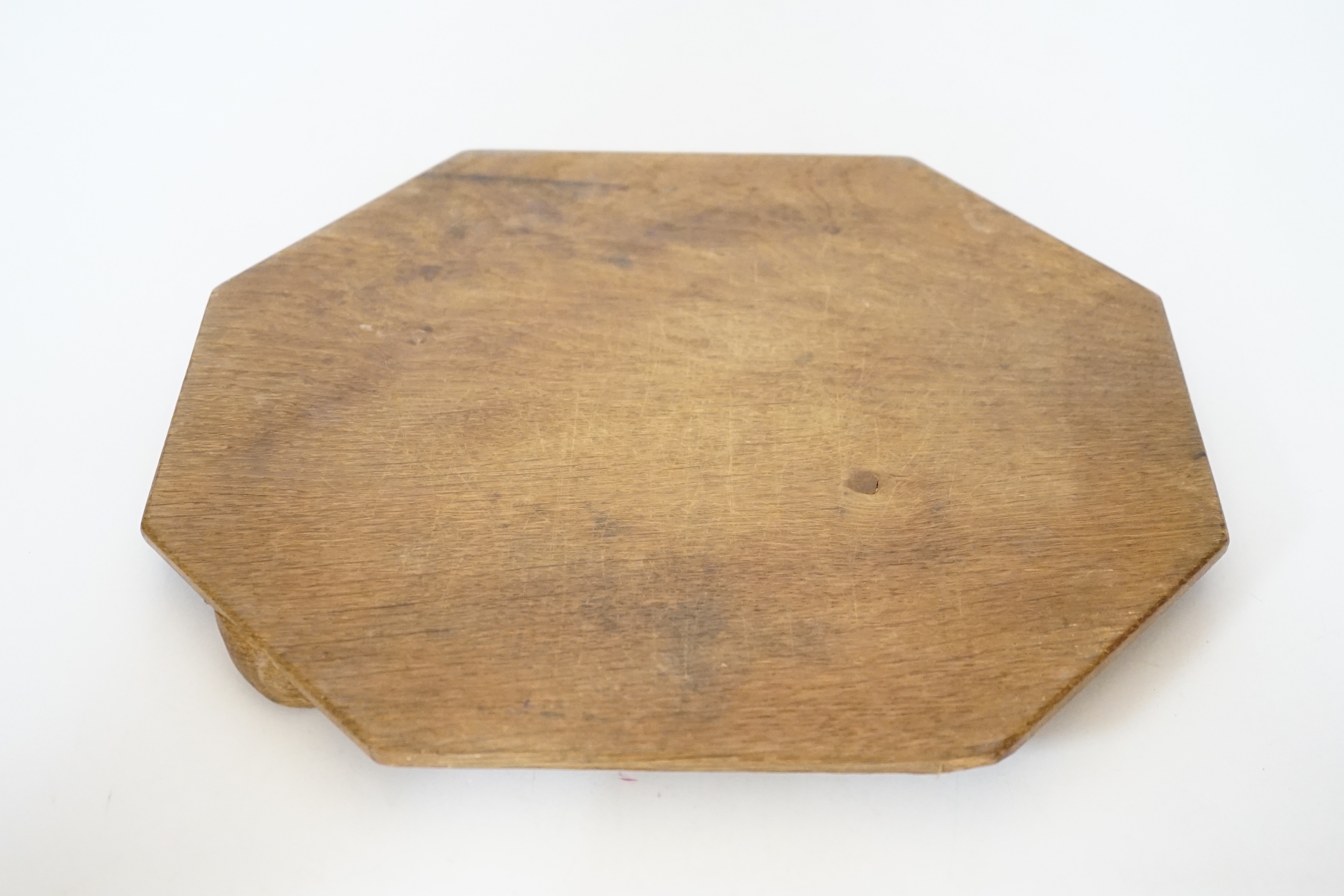 A Robert ‘Mouseman’ Kilburn octagonal carved oak breadboard, 30x25cm